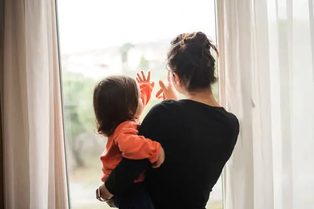 Mother and son looking out of window