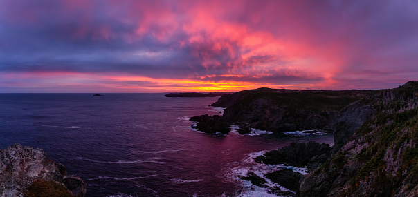 Striking panoramic seascape view on a rocky Atlantic Ocean Coast during a colorful sunrise. Taken at Crow Head, North Twillingate Island, Newfoundland and Labrador, Canada.