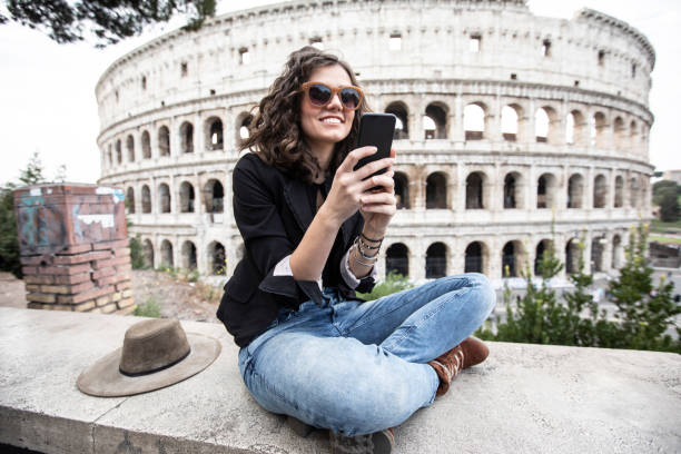 istock Young girl using phone in front of Coliseum 1130187657