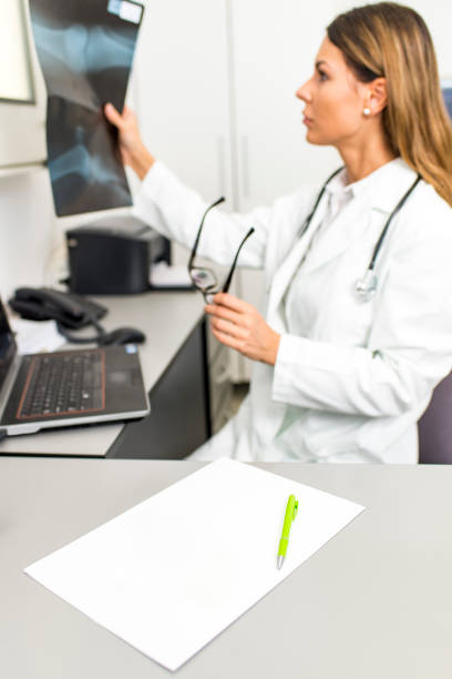 istock Young female doctor or intern looking at  x ray image at her office 1130189356