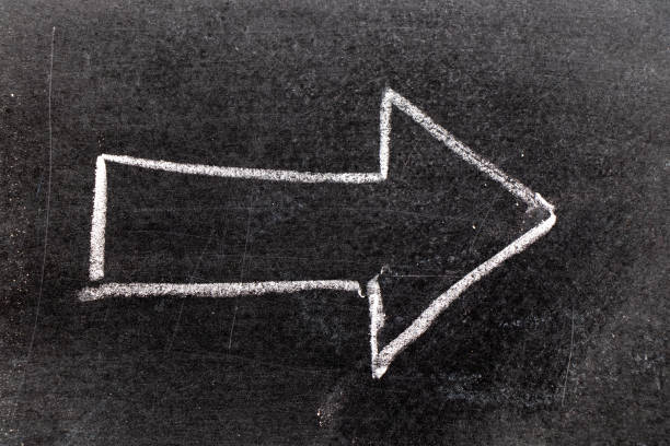 istock White chalk hand drawing in arrow shape on black board background 1130195034