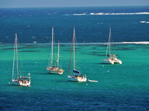 Yachts at Anchor in Paradise Sailboats at anchor in the Tobago Cays Marine Park with nothing but ocean and reef around them. tobago cays stock pictures, royalty-free photos & images
