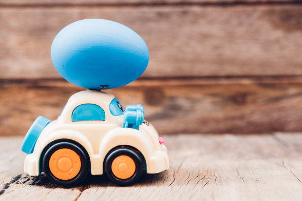 istock Easter egg and toy car on wooden background 1130205497