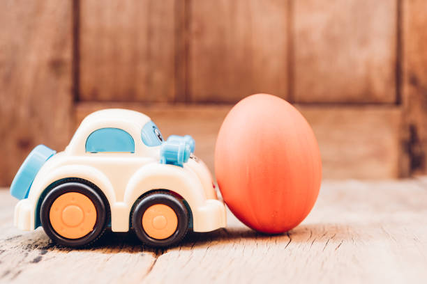 istock Easter egg and toy car on wooden background 1130205501