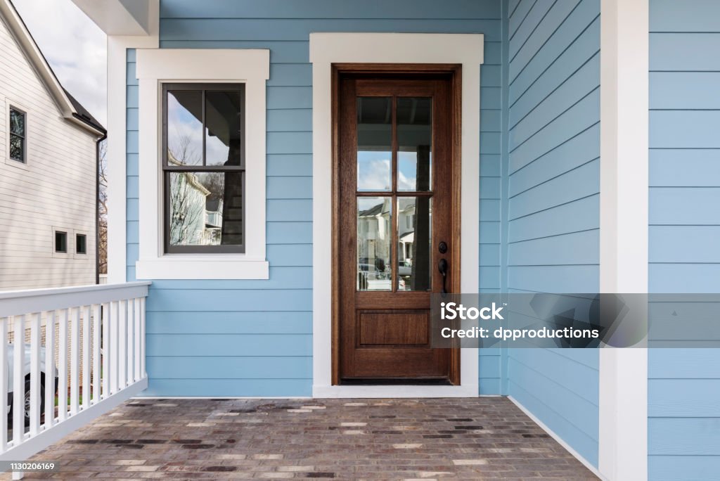 Brown front door of a house Front brown door with a nice pale blue exterior Front Door Stock Photo