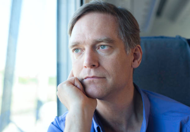istock Caucasian man in blue shirt sitting on train at daytime 1130211371