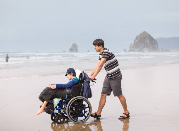 istock Young man pushing disabled brother in wheelchair on beach 1130211995