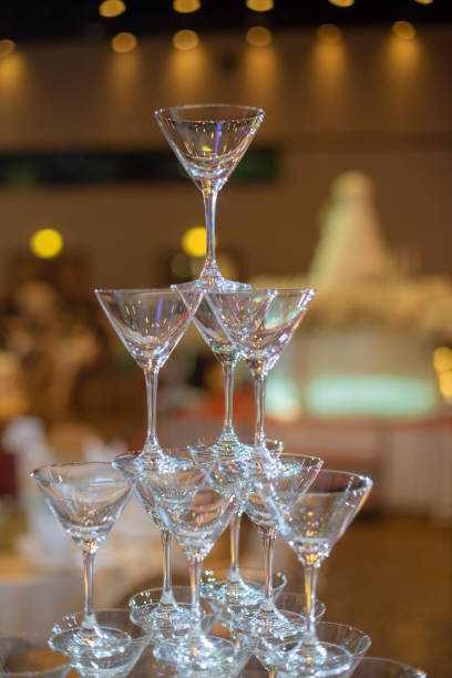 Many wine glasses stacked on night wedding party.