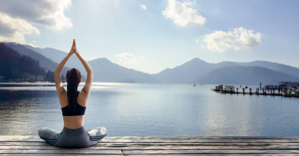 mujer practicando yoga en la naturaleza - lake asia young women beautiful people fotografías e imágenes de stock