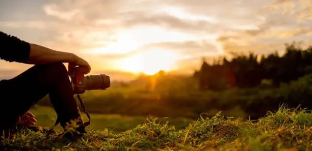 Photo of Photographer are sitting look the sunset