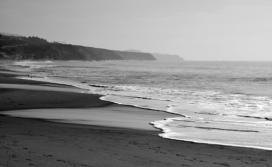 A black and white snapshot of the surf hitting the shore at Crystal Cove Beach in Orange County, California.