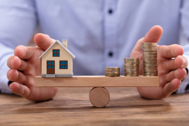 istock House Model And Golden Coins Balancing On Seesaw 1130220100