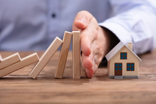 istock Human Hand Protecting Piggybank From Falling Wooden Blocks 1130220112