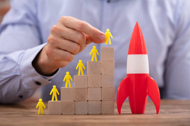 istock Rocket Besides Yellow Human Figures On Top Of Wooden Blocks 1130220137