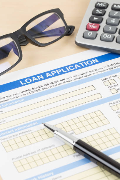 istock Loan application form with calculator, glasses, and pen 1130222163