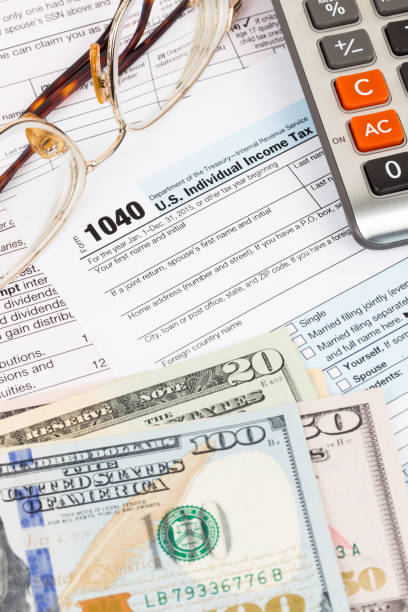 istock Tax form with calculator, glasses, and dollar banknote 1130222766