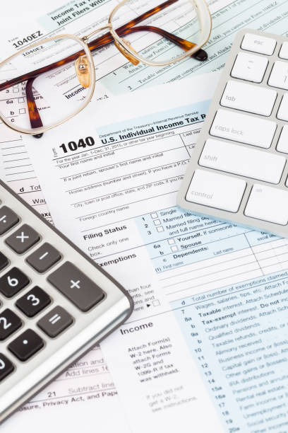 istock Tax form with calculator, glasses, and keyboard 1130222794