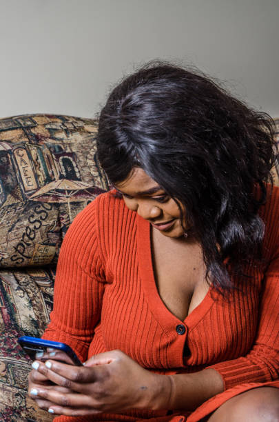 istock Young black woman texting on her mobile phone 1130222858