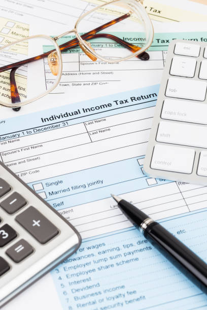 istock Tax form with calculator, glasses, keyboard, and pen; document are mock-up 1130222957