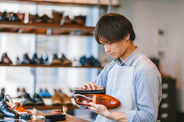 Young man shoeshiner polishing shoes A young man shoeshiner is polishing shoes in his work place. shoe polish photos stock pictures, royalty-free photos & images