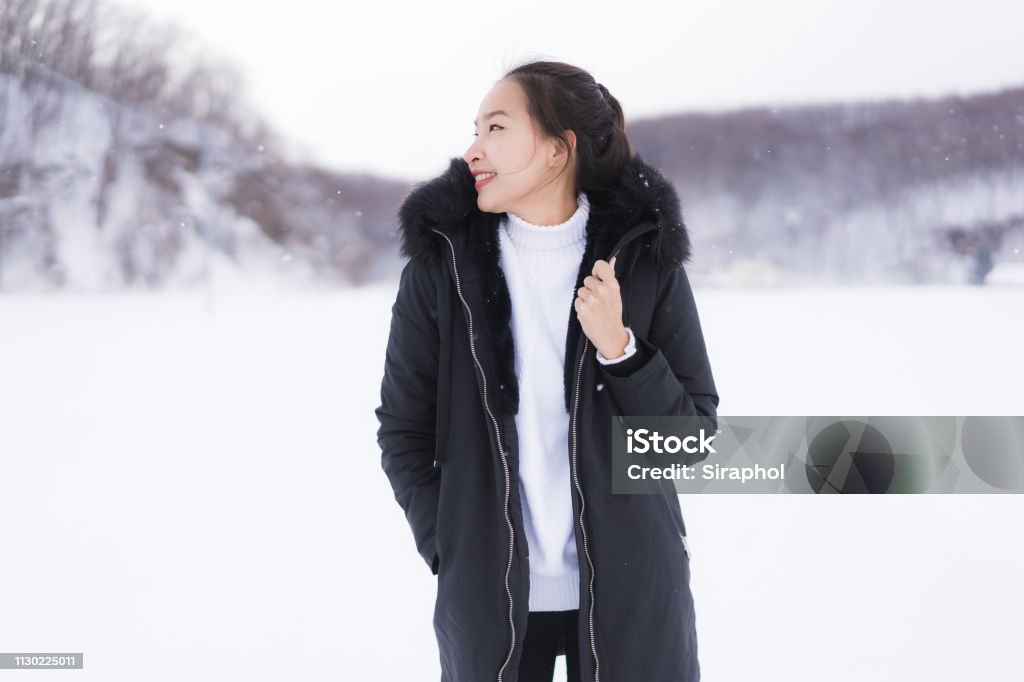 Schöne junge asiatische Frau lächelt glücklich für die Reise im Schnee Wintersaison - Lizenzfrei Attraktive Frau Stock-Foto