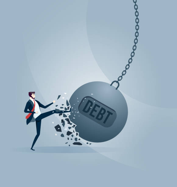 istock Businessman kicks a giant wrecking ball with a word DEBT. 1130225076