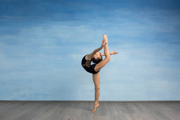istock A young girl gymnast performs kick back and bend in the back, arms straightened back. 1130226962