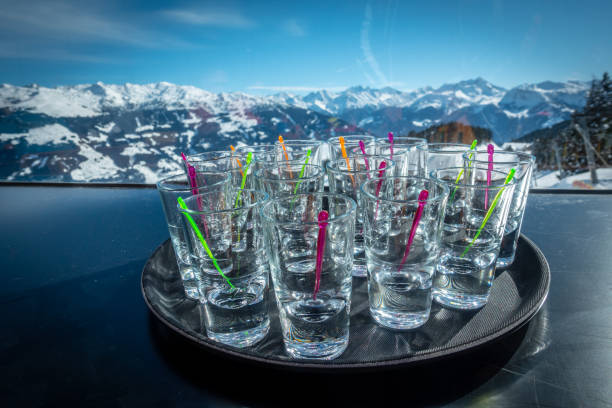 Apre ski drinking alcohol many schnapps glasses in front of a blue sky in a skiing area, drink alcohol on the slopes apres ski stock pictures, royalty-free photos & images