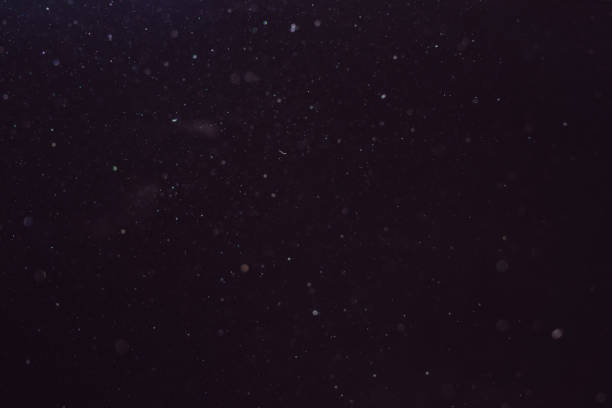 istock Dust in the air illuminated by light on a dark background 1130228960