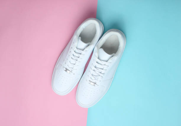 istock Fashionable white sneakers on a colored pastel background, minimalism, top view, creative layout 1130229255