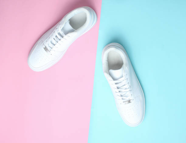 istock Fashionable white sneakers on a colored pastel background, minimalism, top view, creative layout 1130229259