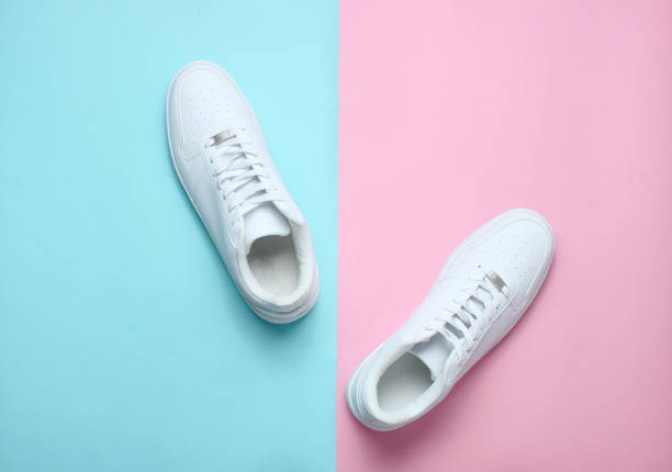 istock Fashionable white sneakers on a colored pastel background, minimalism, top view, creative layout 1130229263