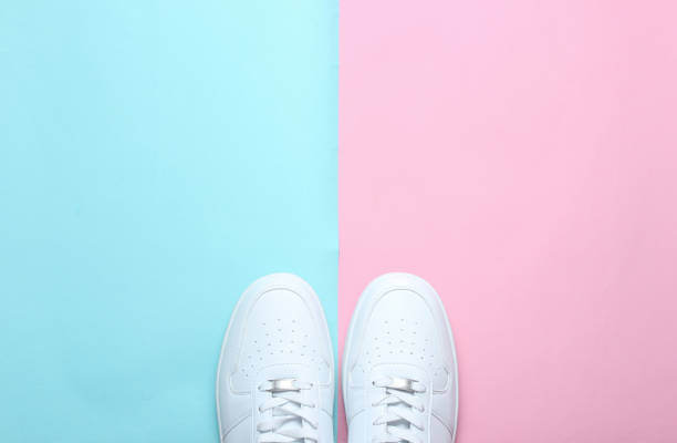 istock Fashionable white sneakers on a colored pastel background, minimalism, top view, creative layout 1130229267