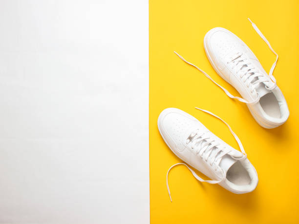 istock Fashionable white sneakers on a colored pastel background, minimalism, top view, creative layout 1130229271