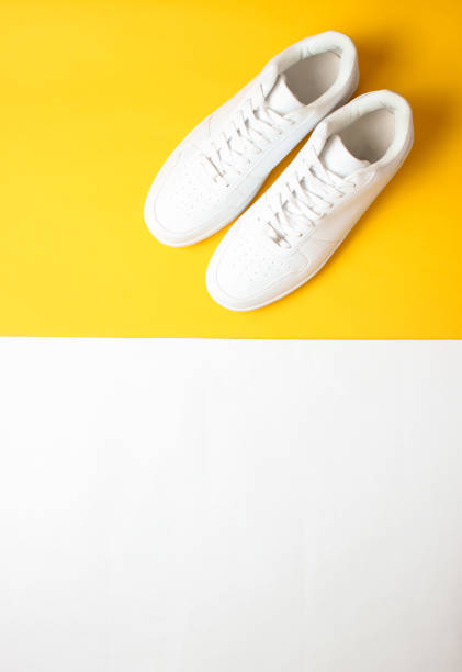 istock Fashionable white sneakers on a colored pastel background, minimalism, top view, creative layout 1130229274