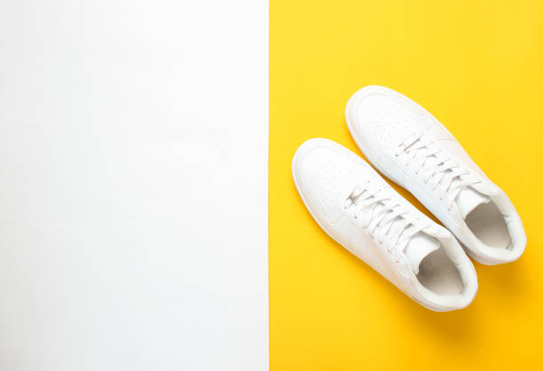 istock Fashionable white sneakers on a colored pastel background, minimalism, top view, creative layout 1130229282