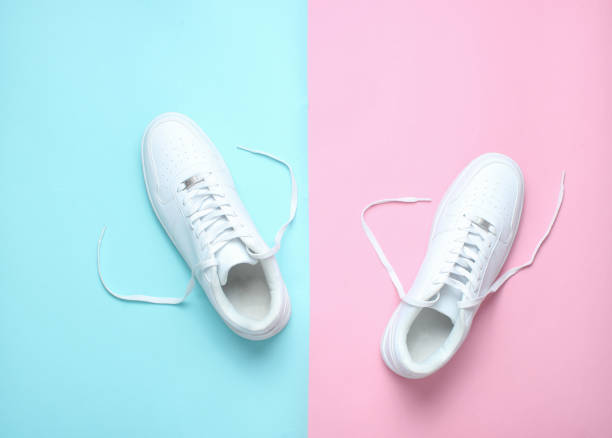 istock Fashionable white sneakers on a colored pastel background, minimalism, top view, creative layout 1130229301