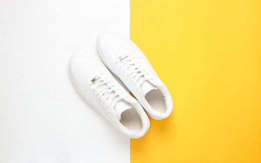 Fashionable white sneakers on a colored pastel background, minimalism, top view, creative layout