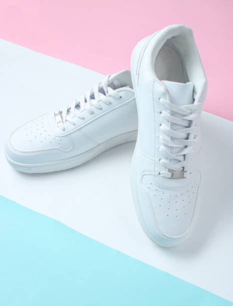 istock Fashionable white sneakers on a colored pastel background, minimalism, top view, creative layout 1130229826