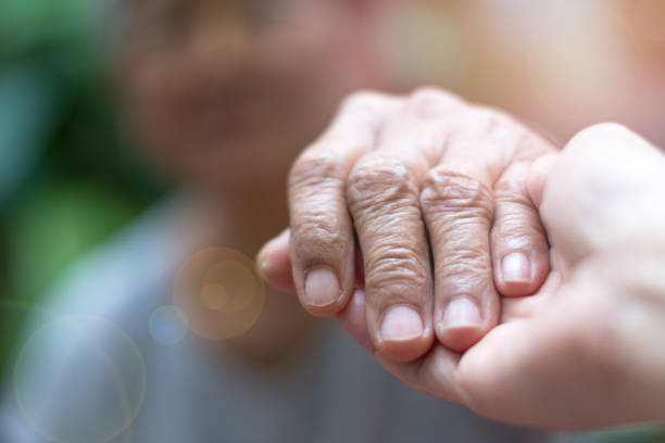 caregiver, carer hand holding elder hand woman in hospice care. philanthropy kindness to disabled concept.public service recognition week - community outreach fotos imagens e fotografias de stock