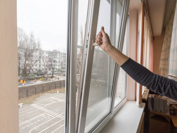 A hand opens a window to air the room stock photo