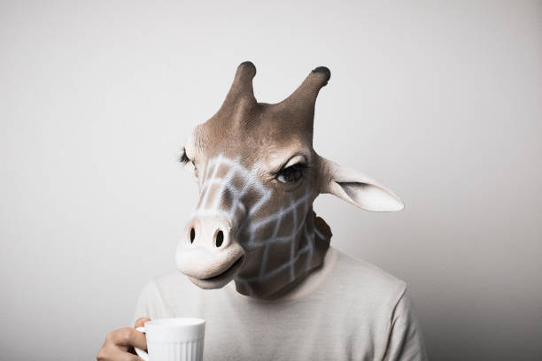 istock Portrait of man with giraffe mask drinking coffee 1130232977