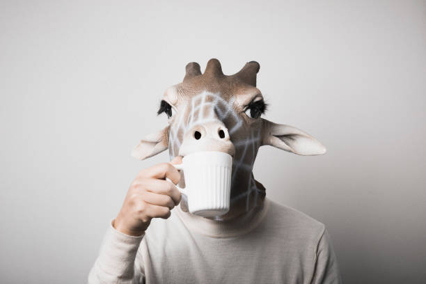 Portrait of man with giraffe mask drinking coffee