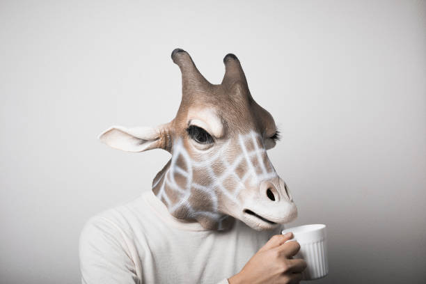istock Portrait of man with giraffe mask drinking coffee 1130232990