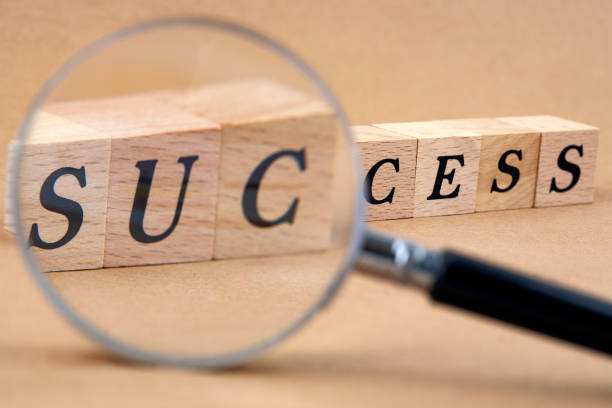 istock success word cubes with magnifying glass 1130235991