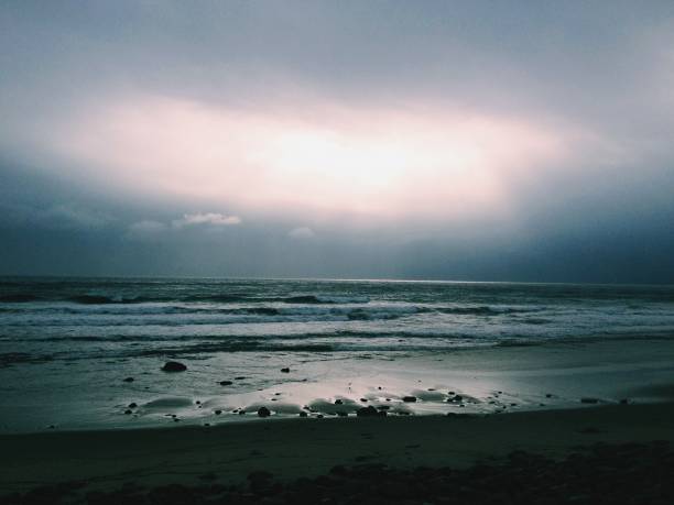 istock Beautiful light breaks through dark skies above the Pacific Ocean 1130236134