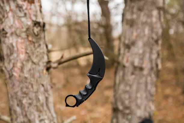 istock karambit knife hanging on the branch in the autumn forest 1130236326