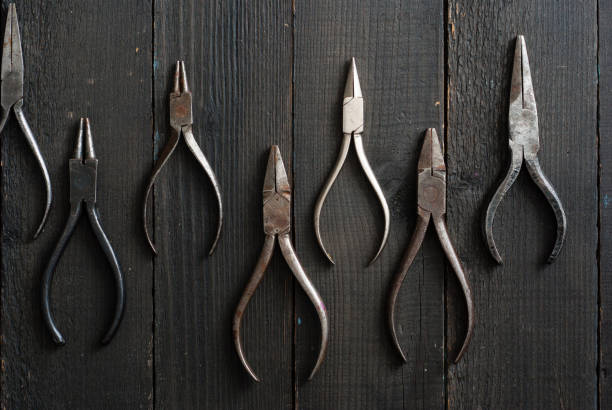 istock Used pliers top view on black hardwood 1130237219