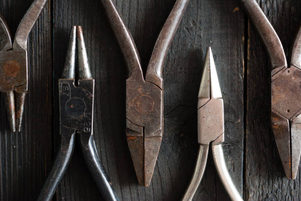 istock Used pliers top view on black hardwood 1130237998