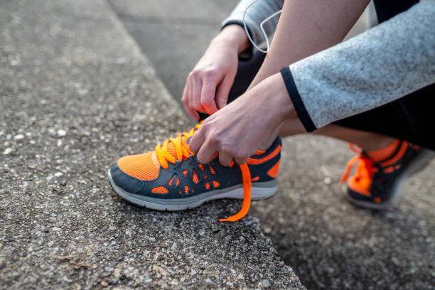 istock young woman trail runner tying shoelaces 1130239276